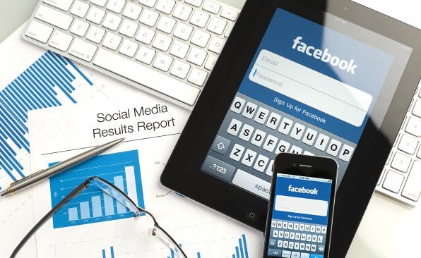 Ipad and iphone on a desk showing facebook