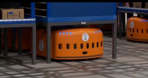 Der Kiva-Roboter platziert sich unter einem Regal, schraubt sich durch Dreh-Bewegungen in die Höhe und „trägt" dann das Regal mit sich fort. (Bild: Kiva Systems)