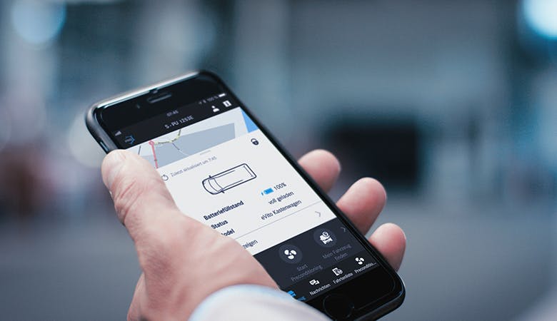 Ein Apple-Smartphone in der Hand eines Nutzers zeigt die für den eVito verfügbare App für Android oder iOS